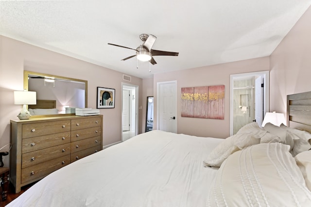 bedroom with hardwood / wood-style flooring, ceiling fan, and ensuite bath