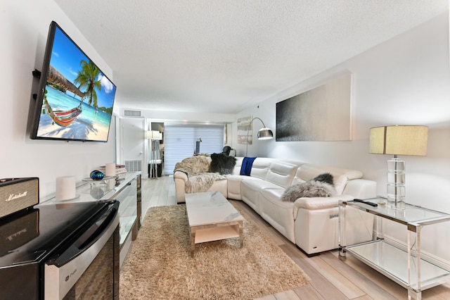 living room featuring a textured ceiling and light hardwood / wood-style floors