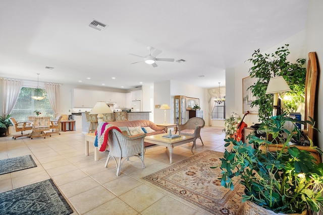 living room with light tile patterned floors and ceiling fan with notable chandelier