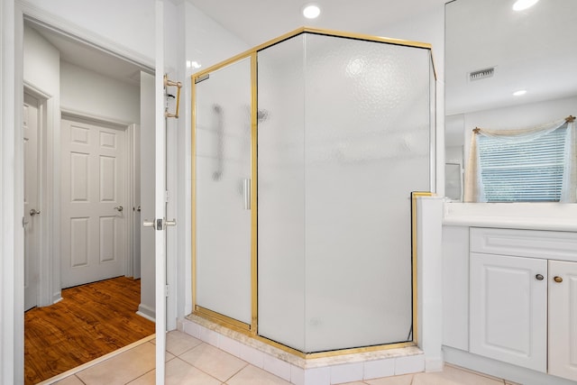 bathroom featuring an enclosed shower and wood-type flooring