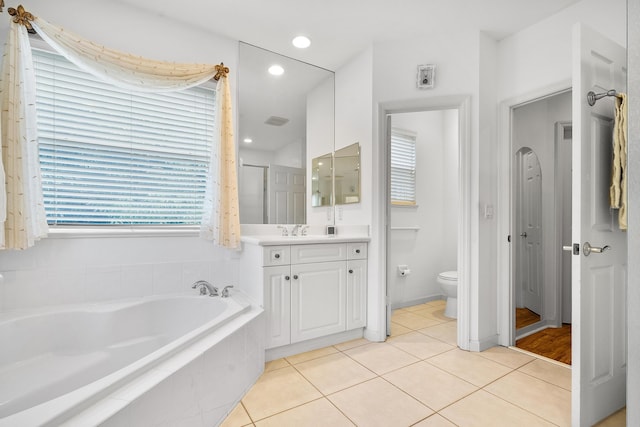 bathroom featuring tile patterned floors, vanity, toilet, and tiled tub