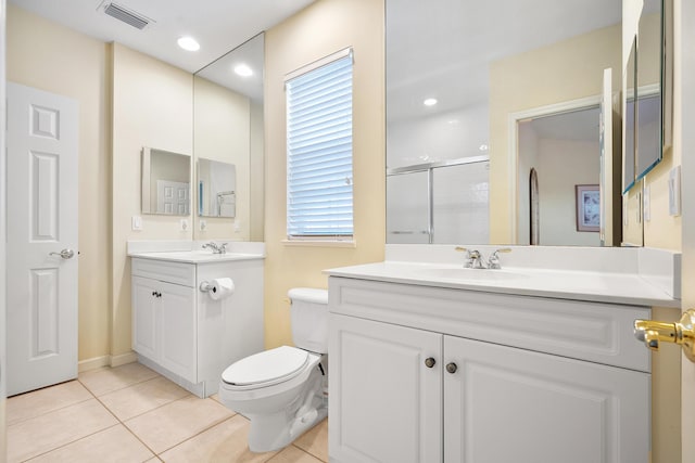 bathroom with tile patterned floors, vanity, toilet, and a shower with shower door