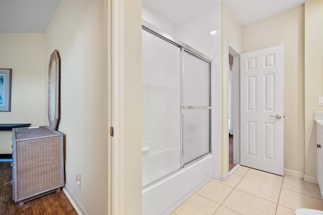 bathroom with tile patterned flooring, vanity, and bath / shower combo with glass door