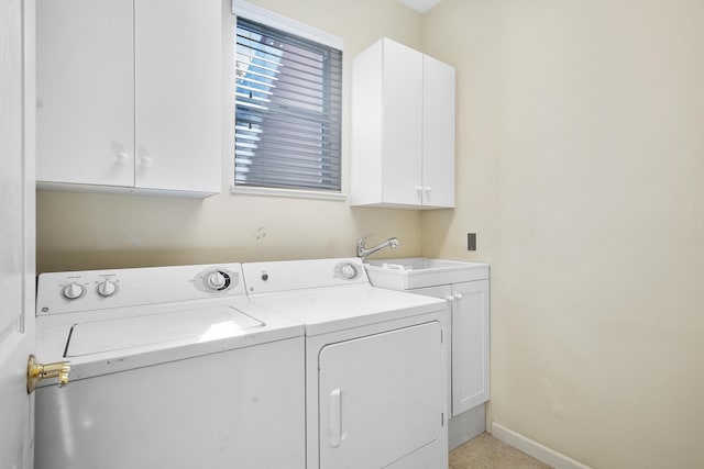 laundry area with washing machine and clothes dryer, sink, and cabinets