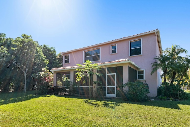 rear view of property with a yard and a sunroom