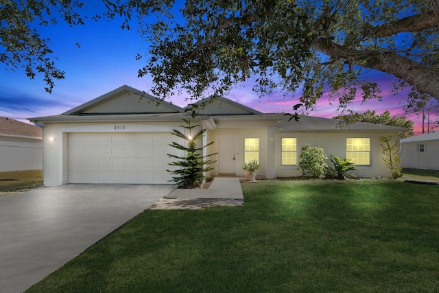 ranch-style home featuring a lawn and a garage