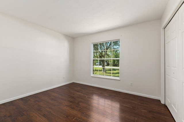 unfurnished bedroom featuring a closet and dark hardwood / wood-style flooring