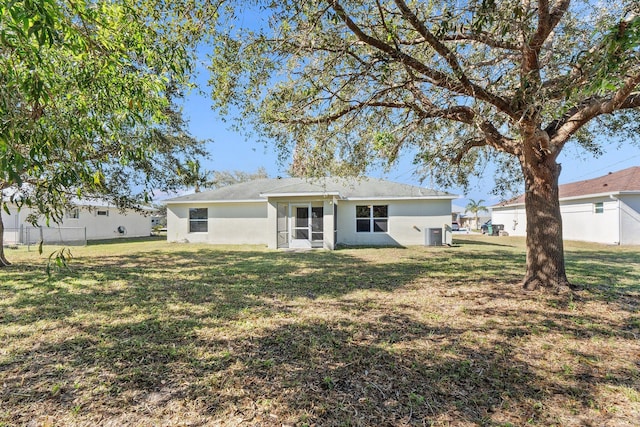 rear view of property featuring a lawn