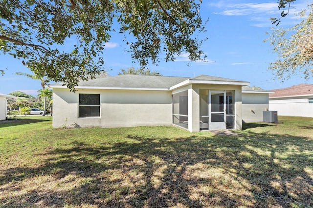 rear view of property with a lawn, a sunroom, and cooling unit