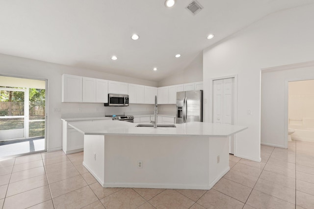 kitchen with white cabinetry, sink, stainless steel appliances, a center island with sink, and light tile patterned flooring