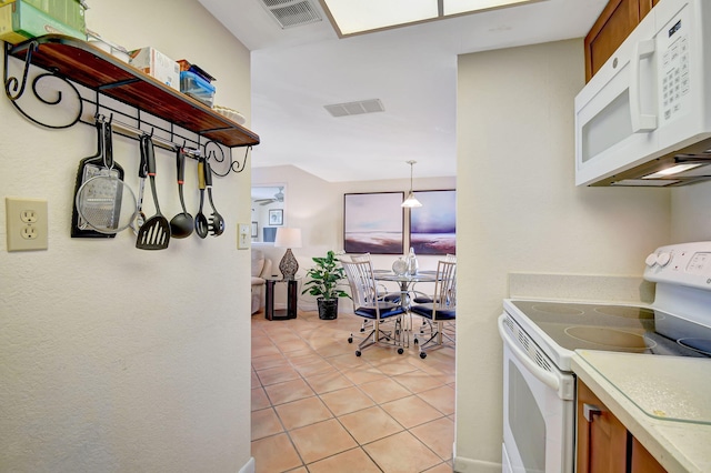 kitchen with light tile patterned floors, decorative light fixtures, and white appliances