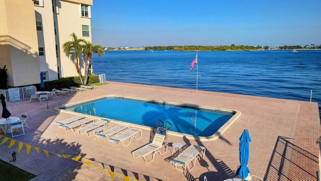 view of swimming pool featuring a patio area and a water view