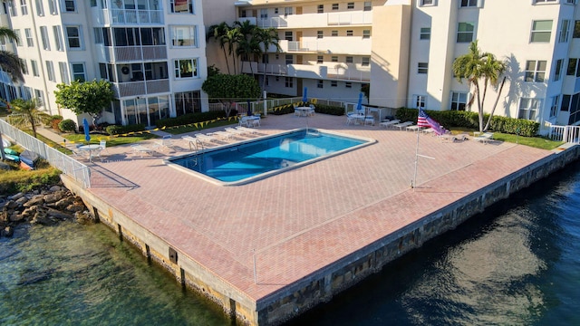 view of pool with a patio and a water view