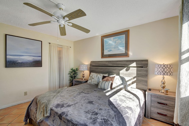 tiled bedroom featuring ceiling fan and a textured ceiling