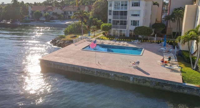 view of swimming pool with a patio area and a water view