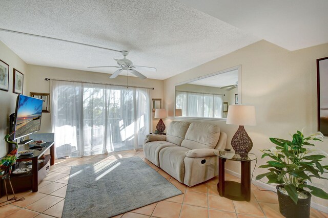 tiled living room with ceiling fan and a textured ceiling