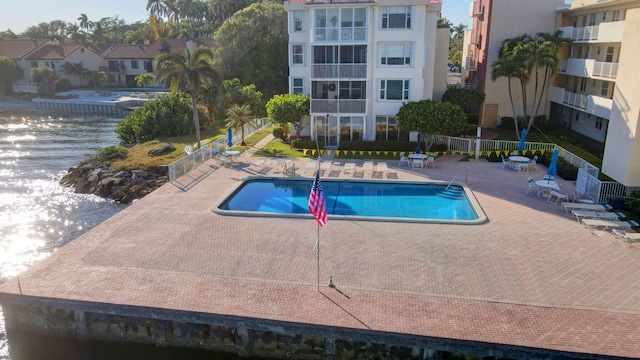 view of pool featuring a patio and a water view