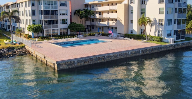 view of pool featuring a patio area and a water view