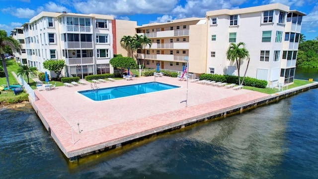 view of swimming pool featuring a patio area and a water view