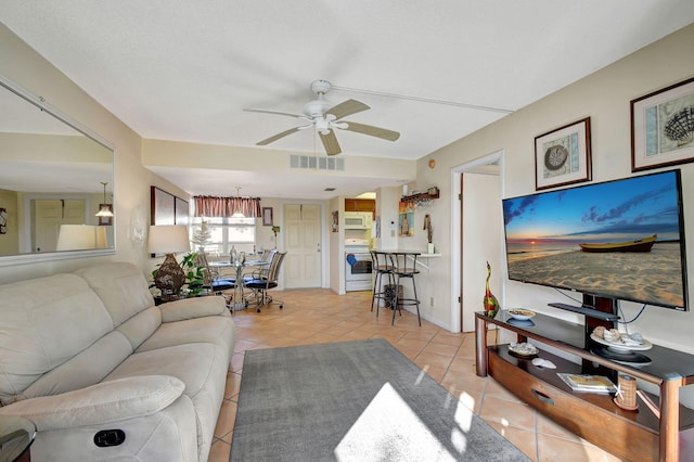 living room with ceiling fan and light tile patterned flooring