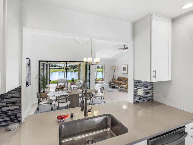 kitchen with backsplash, decorative light fixtures, a water view, dishwasher, and white cabinetry