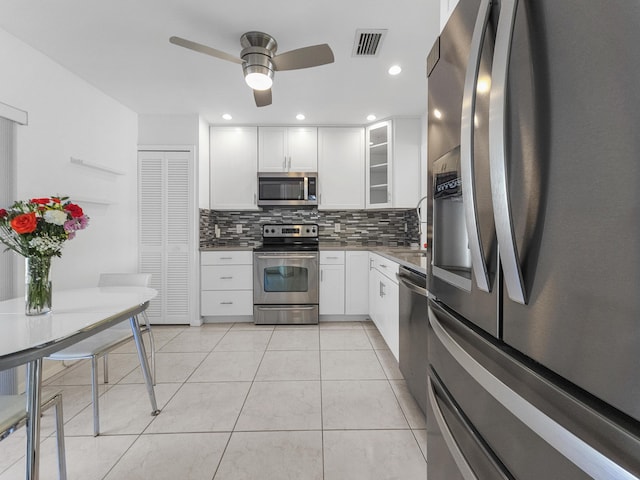 kitchen featuring decorative backsplash, appliances with stainless steel finishes, ceiling fan, light tile patterned floors, and white cabinetry