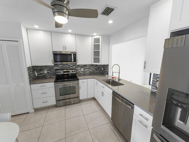 kitchen with white cabinets, stainless steel appliances, tasteful backsplash, and sink