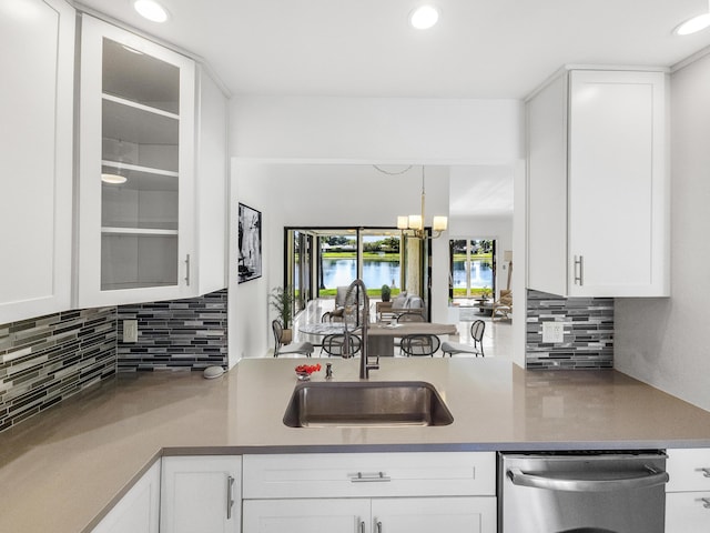 kitchen with tasteful backsplash, dishwasher, sink, and white cabinets