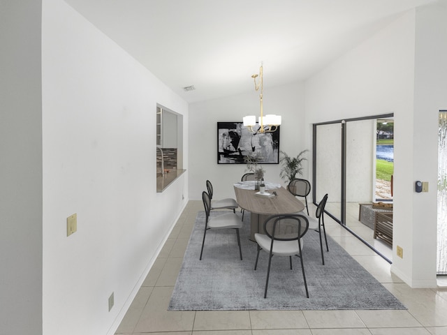 dining room with a notable chandelier, light tile patterned flooring, and lofted ceiling