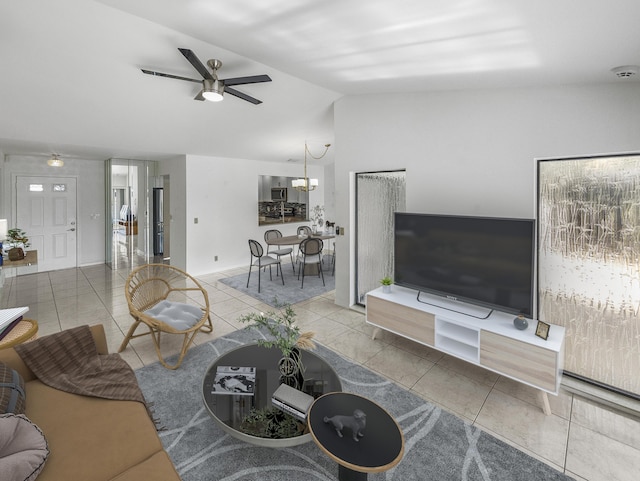 living room featuring tile patterned floors, ceiling fan with notable chandelier, and vaulted ceiling