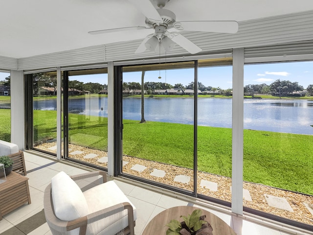 sunroom featuring ceiling fan and a water view