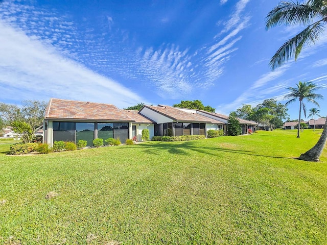 rear view of property featuring a lawn