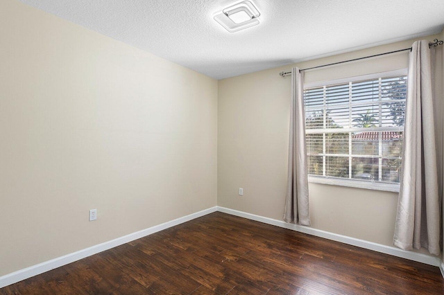 unfurnished room with dark hardwood / wood-style flooring and a textured ceiling