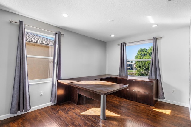 unfurnished dining area featuring dark hardwood / wood-style flooring and a textured ceiling