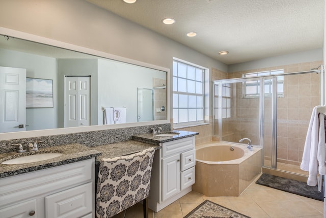 bathroom with tile patterned flooring, vanity, a textured ceiling, and plus walk in shower