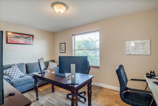 home office featuring a textured ceiling and light hardwood / wood-style flooring