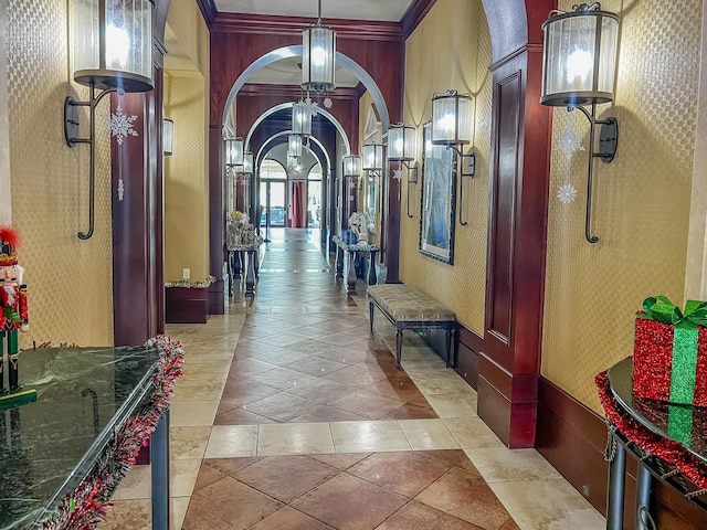 corridor with light tile patterned floors and ornamental molding