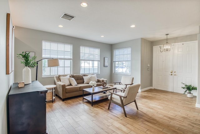 living room featuring light hardwood / wood-style flooring and an inviting chandelier