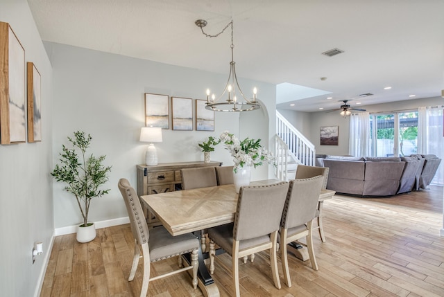 9128 Dupont Pl, Wellington, FL 33414 - dining area with light wood-type flooring, baseboards, a chandelier, a ceiling fan, and stairs
