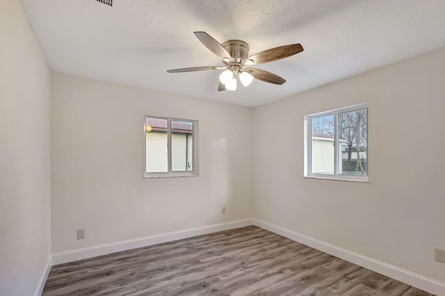 unfurnished room with hardwood / wood-style floors, a textured ceiling, and ceiling fan