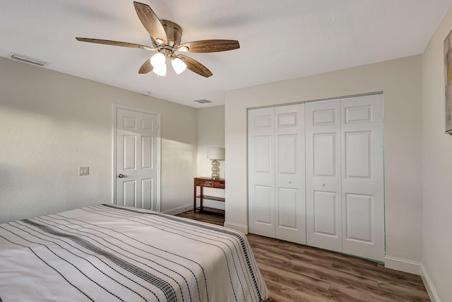 bedroom featuring ceiling fan, dark hardwood / wood-style flooring, and a closet