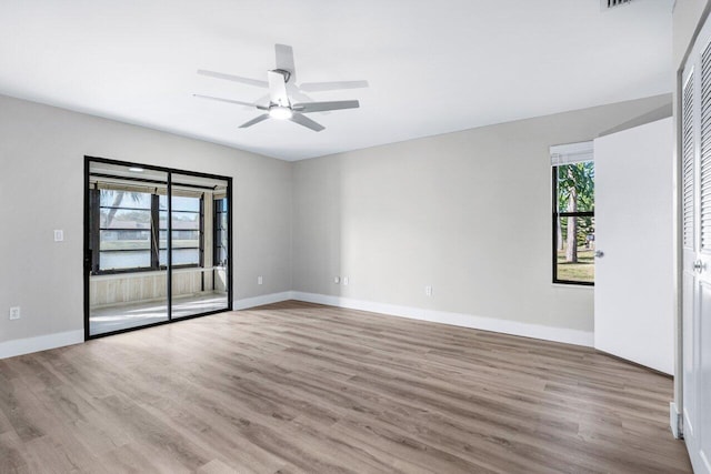 spare room with plenty of natural light, ceiling fan, and light hardwood / wood-style flooring