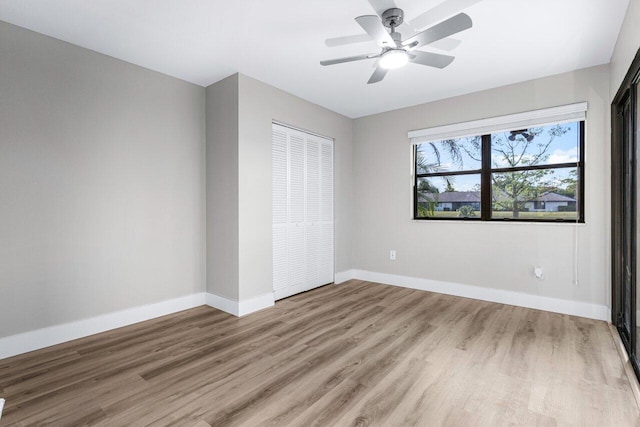 unfurnished bedroom featuring ceiling fan, wood-type flooring, and a closet