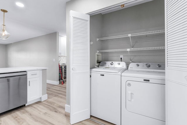 laundry room featuring separate washer and dryer and light hardwood / wood-style flooring