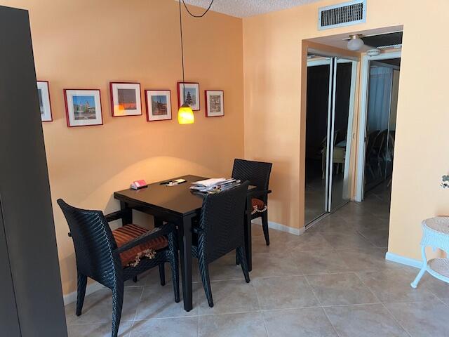 tiled dining room featuring a textured ceiling