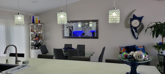 dining space featuring a chandelier, vaulted ceiling, and sink