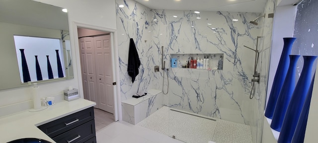 bathroom with tiled shower and vanity