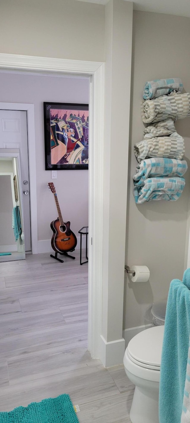 bathroom with wood-type flooring and toilet