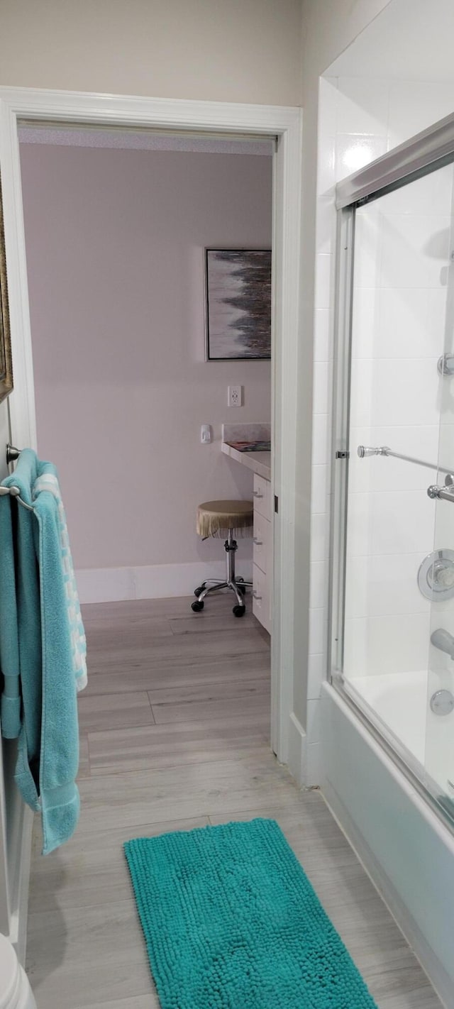 bathroom featuring bath / shower combo with glass door and wood-type flooring