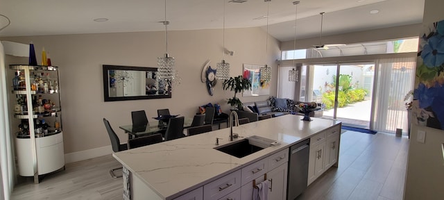 kitchen with dishwasher, an island with sink, white cabinetry, and sink